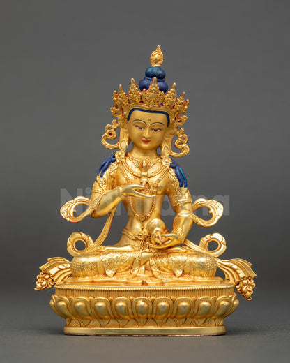 Vajrasattva sculpture with gold-painted face holding vajra and bell