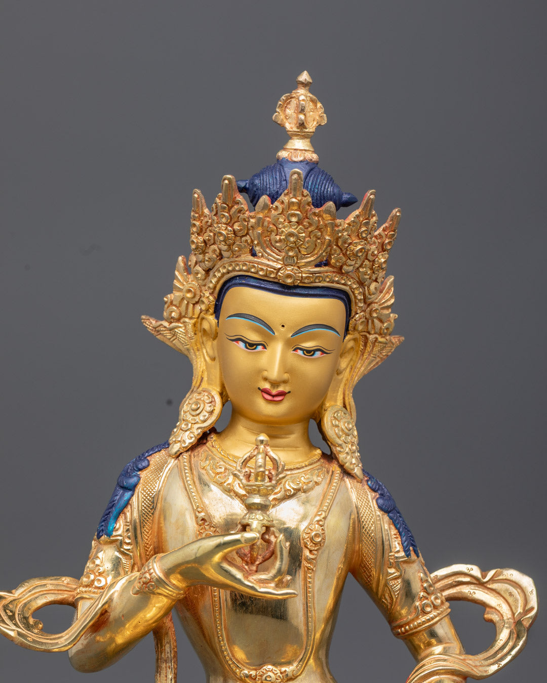 Vajrasattva statue's serene expression, detailed crown, and vajra symbol, showcasing expert Nepalese craftsmanship and lost wax casting detail.