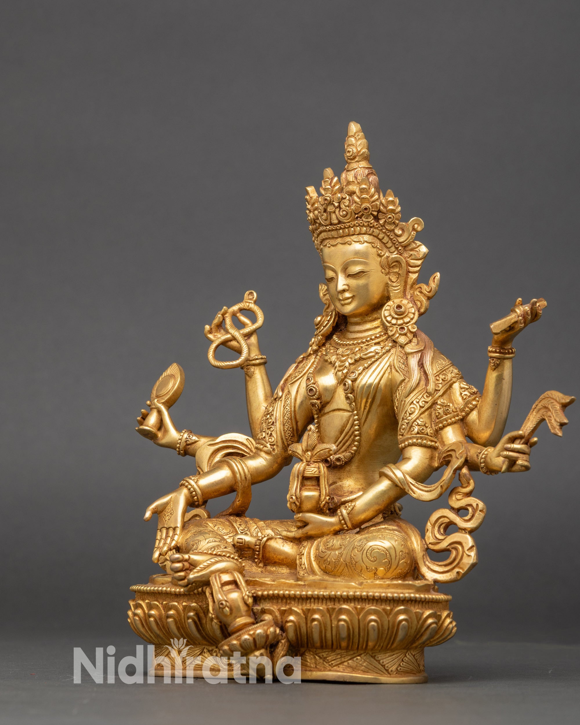 Vasudhara wealth deity statue seated on lotus throne gold gilded Nepalese art