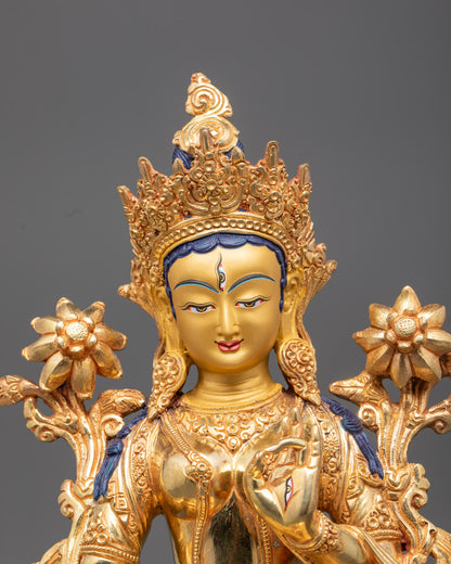  White Tara statue showing intricate carvings on flowing robe, crown, and jewelry with blue utpala flowers