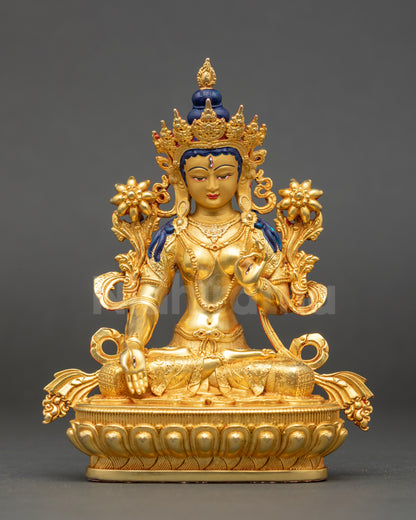 White Tara statue with gold-painted face and seven eyes seated on lotus base