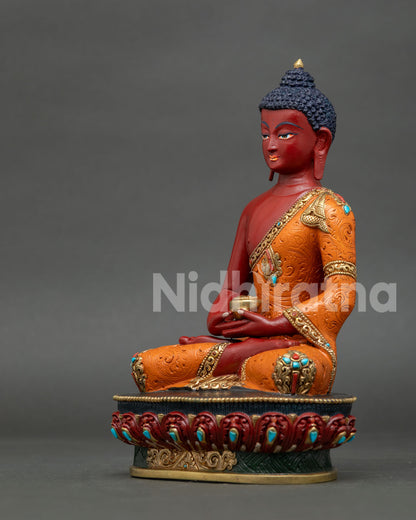 Amitabha Buddha statue with red painted body and intricate orange robe artwork