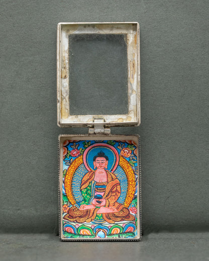 Amitabha Buddha silver locket handcrafted by a skilled Newari artist from Patan, Nepal, with coral stone accents and ornate floral filigree.