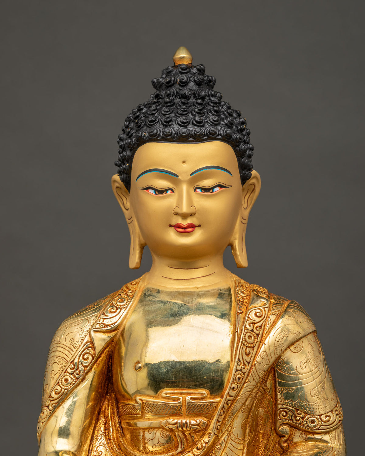 Amitabha Buddha statue close up 24K gold painted face alms bowl.