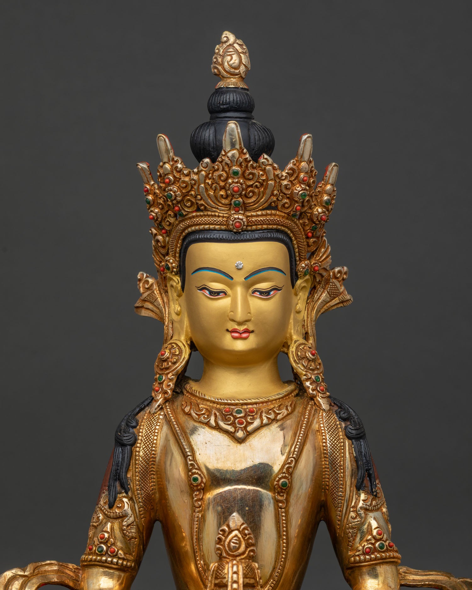 Amitayus Buddha statue regular close up showing gold painted face and intricate ornaments.
