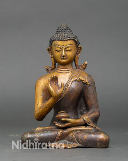 Amoghasiddhi Buddha statue Abhaya mudra raised hand symbol of fearlessness protection and spiritual strength oxidized copper Vajrayana Buddhist art