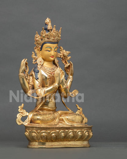Angled side view of gilded Chenrezig Buddha statue seated on lotus pedestal holding a flower