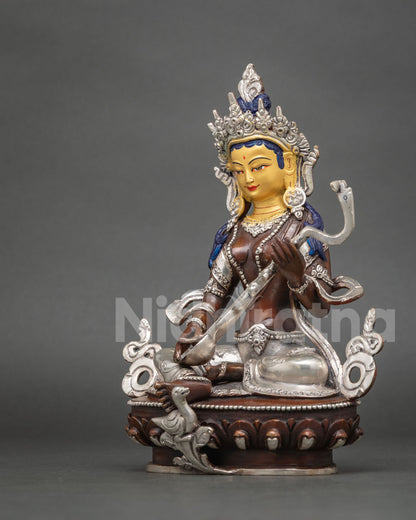 Angled side view of handcrafted Saraswati statue showing veena and silver-plated swan detail