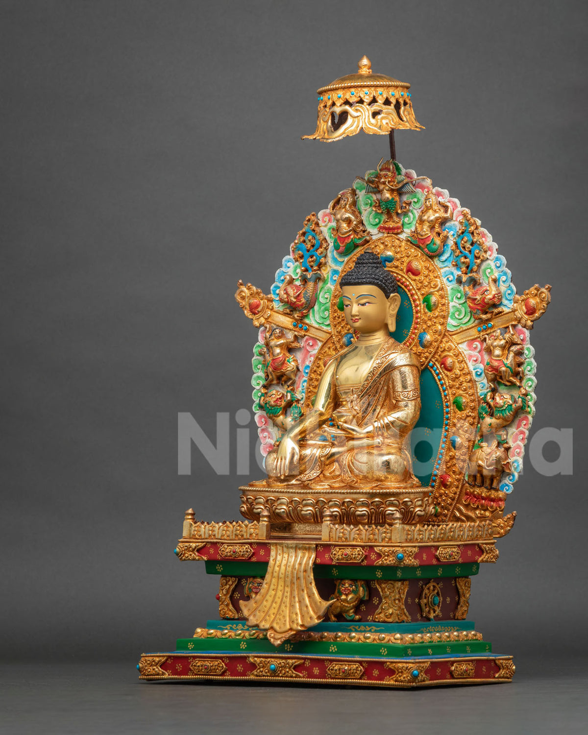 Angled side view of Shakyamuni Buddha statue with lotus pedestal and hand-carved throne base