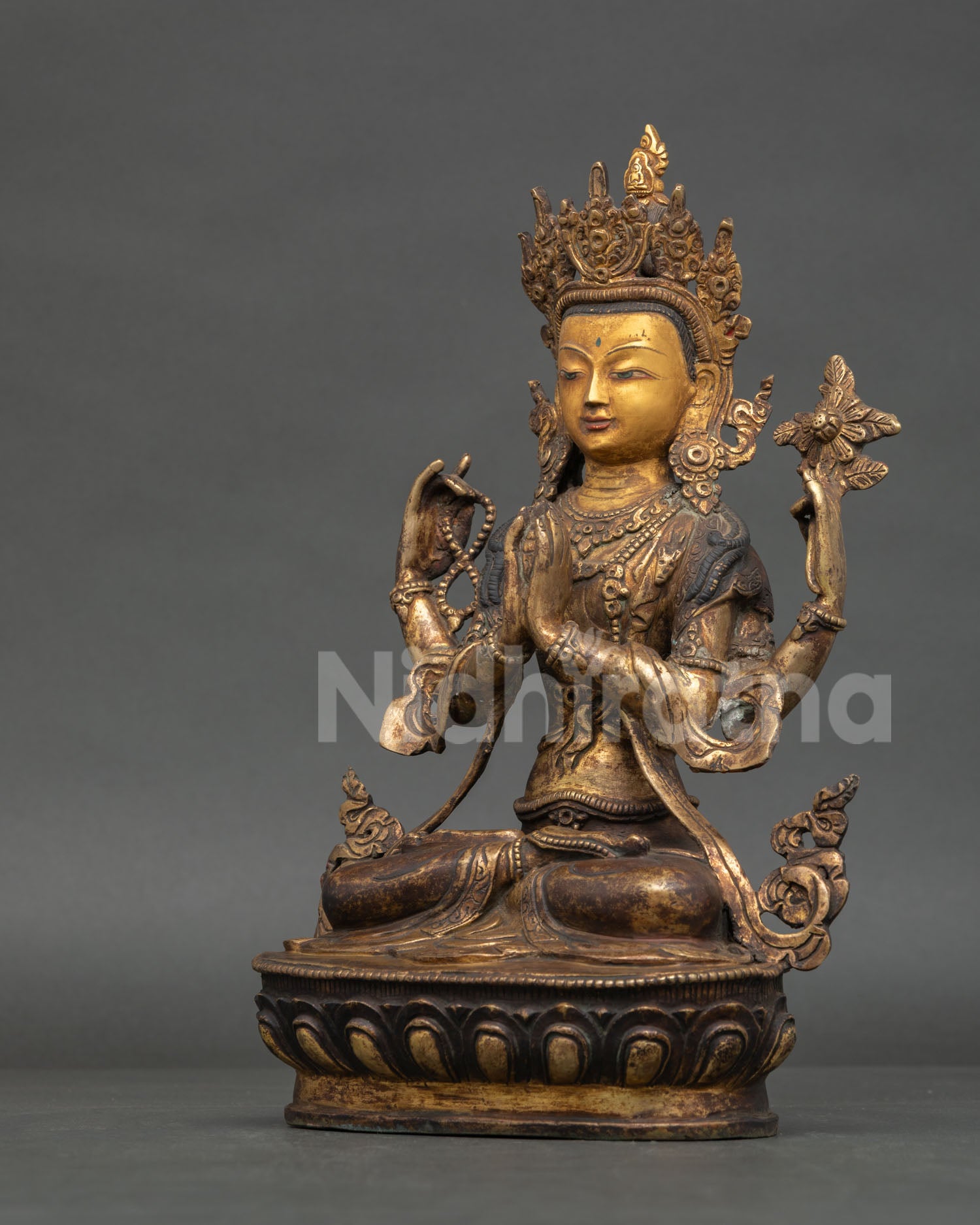 Antique copper Avalokiteshvara sculpture with four arms and sacred Buddhist symbolism