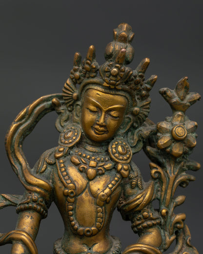 Avalokiteshvara statue close up showing serene gold painted face five jeweled crown and intricate ornaments.
