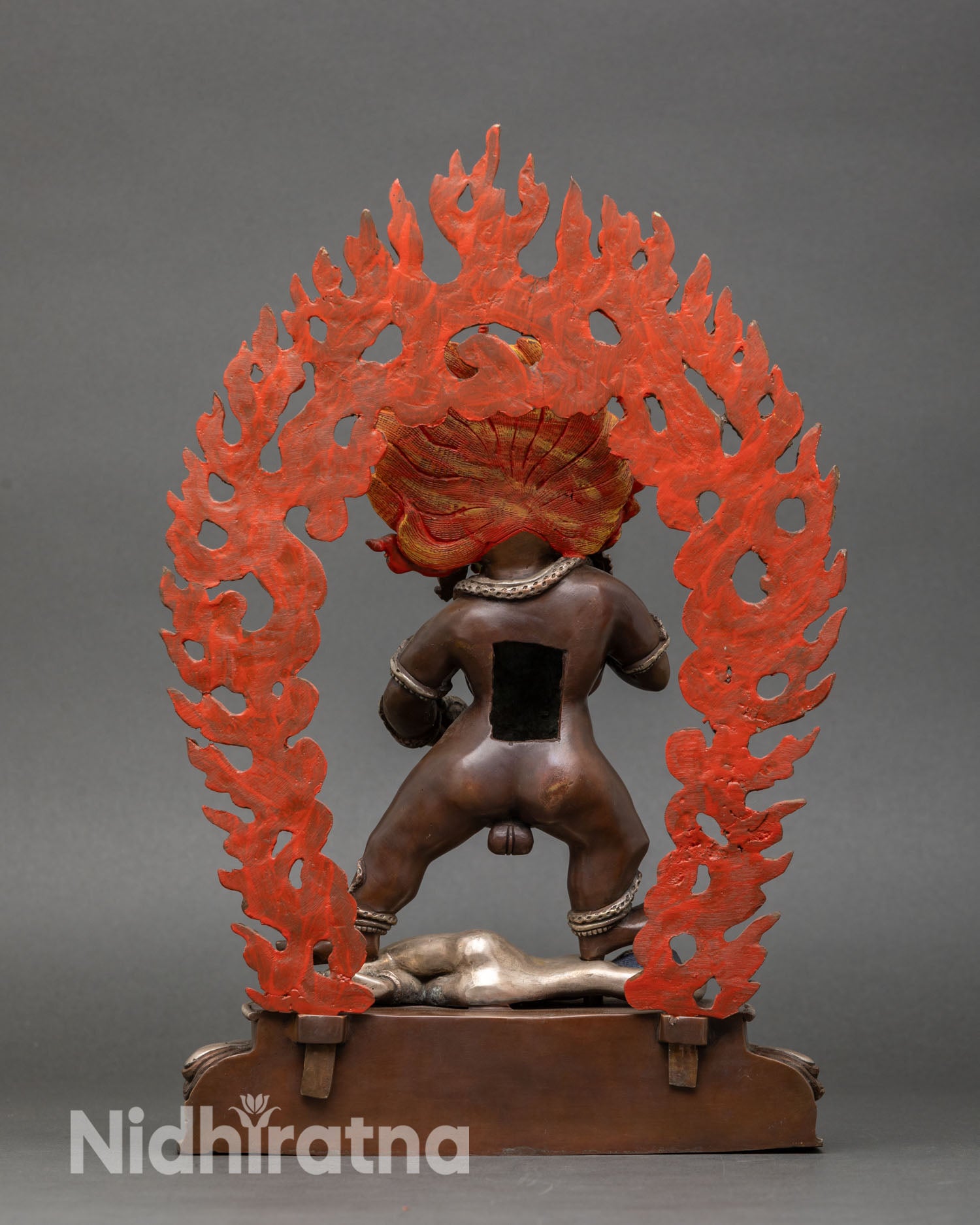 Back view of Black Dzambhala statue, ornate halo, lotus base, sacred decor