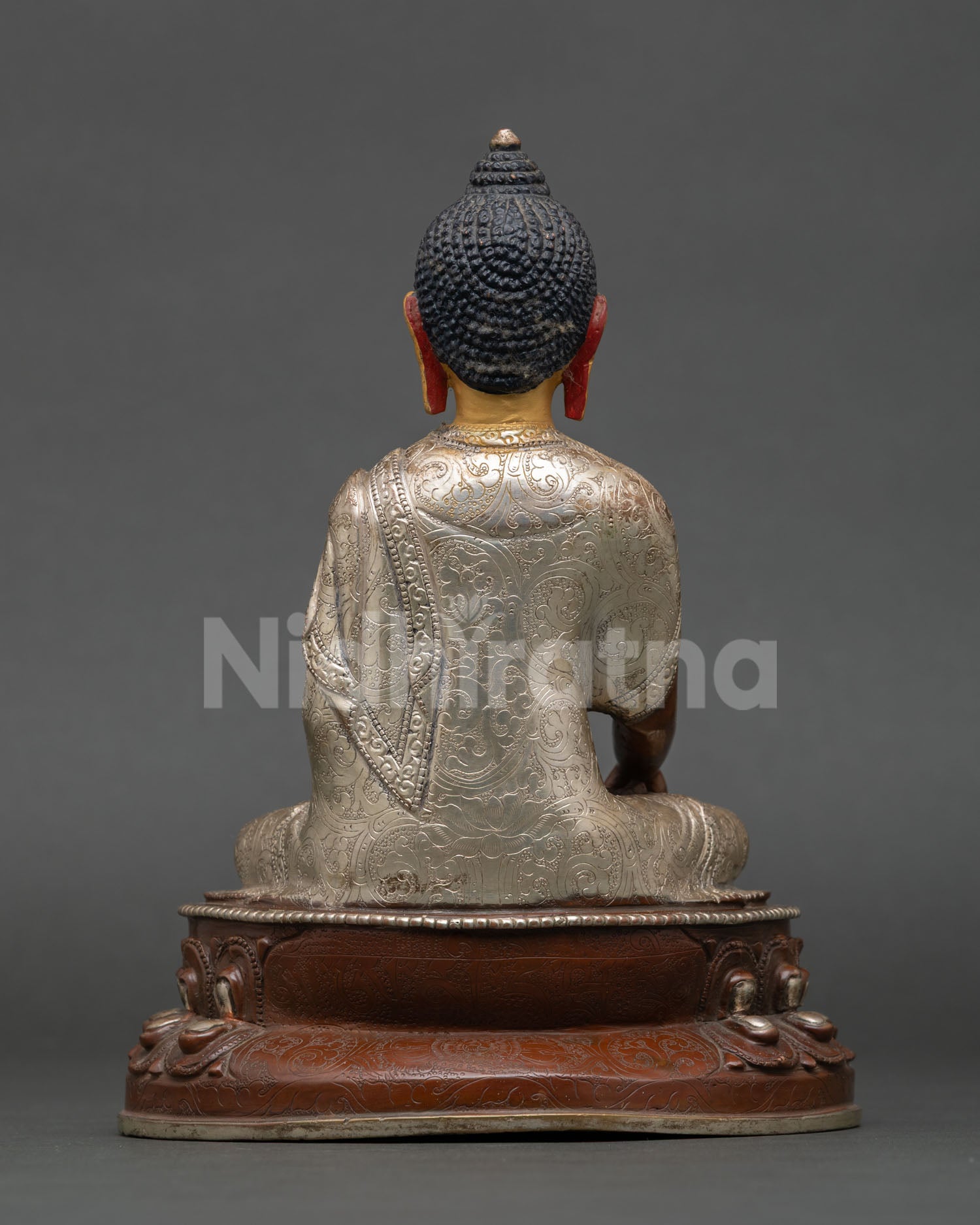 Back view of Buddhist Shakyamuni Buddha sculpture with flowing monastic robes