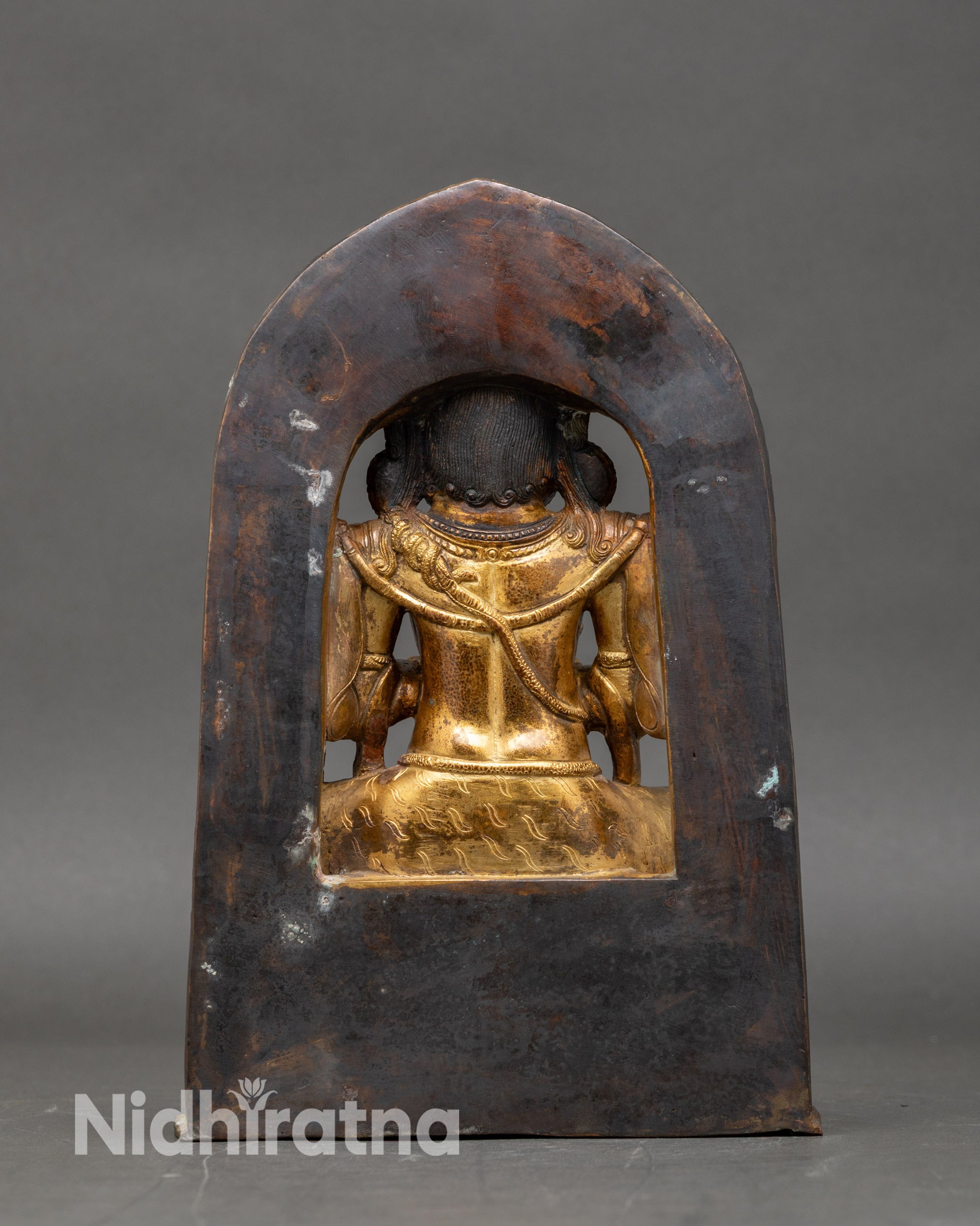 back-view chaturbhuja mahakala statue torana arch and engraved sacred motifs