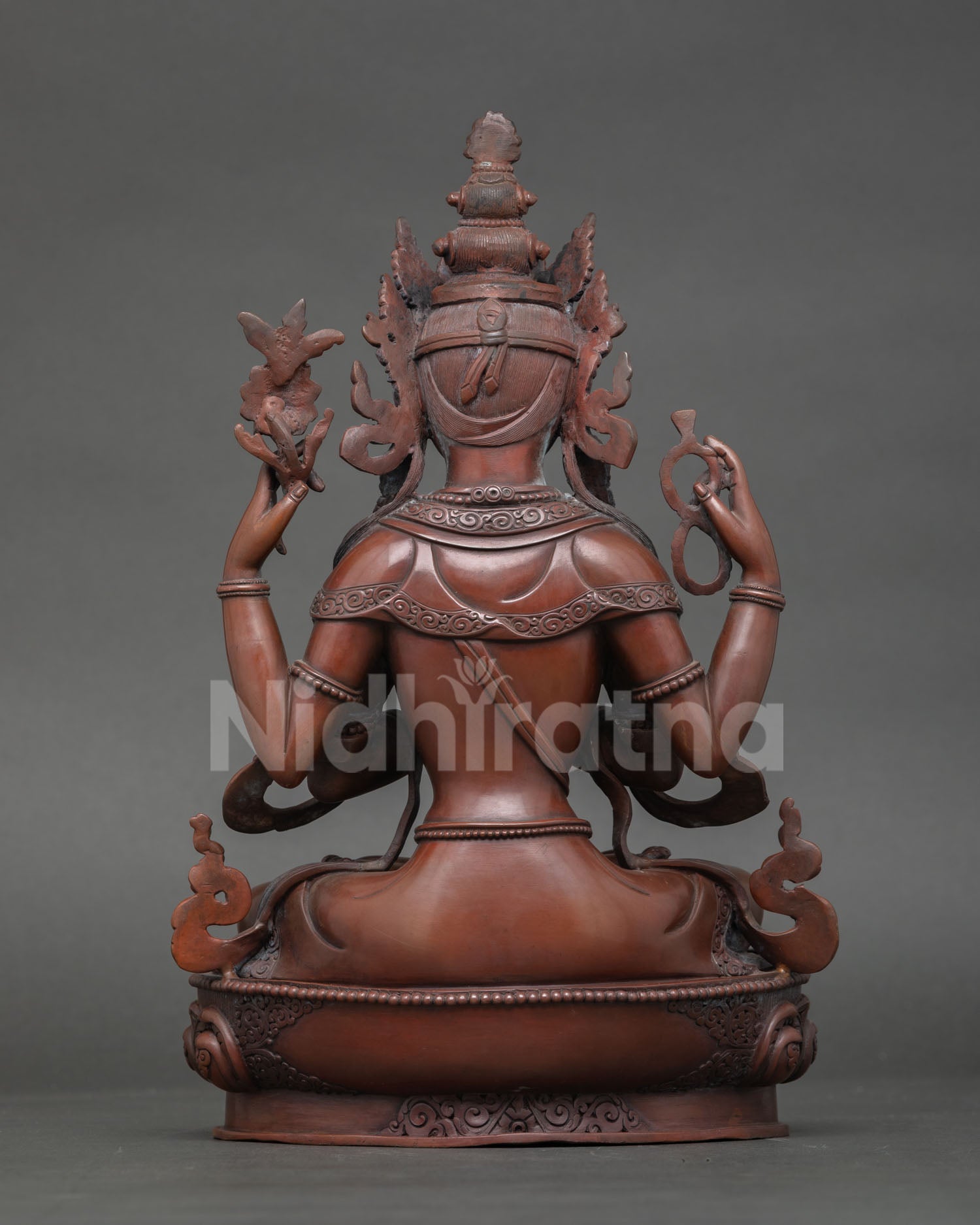 Back view of Chenrezig statue showing detailed carving and oxidized copper finish