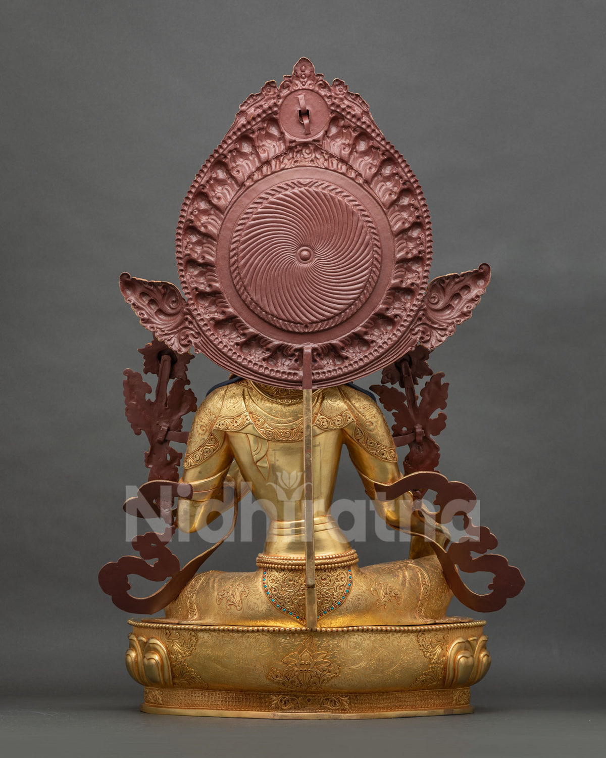 Back view of Green Tara statue showing gold fire-gilded halo and robe
