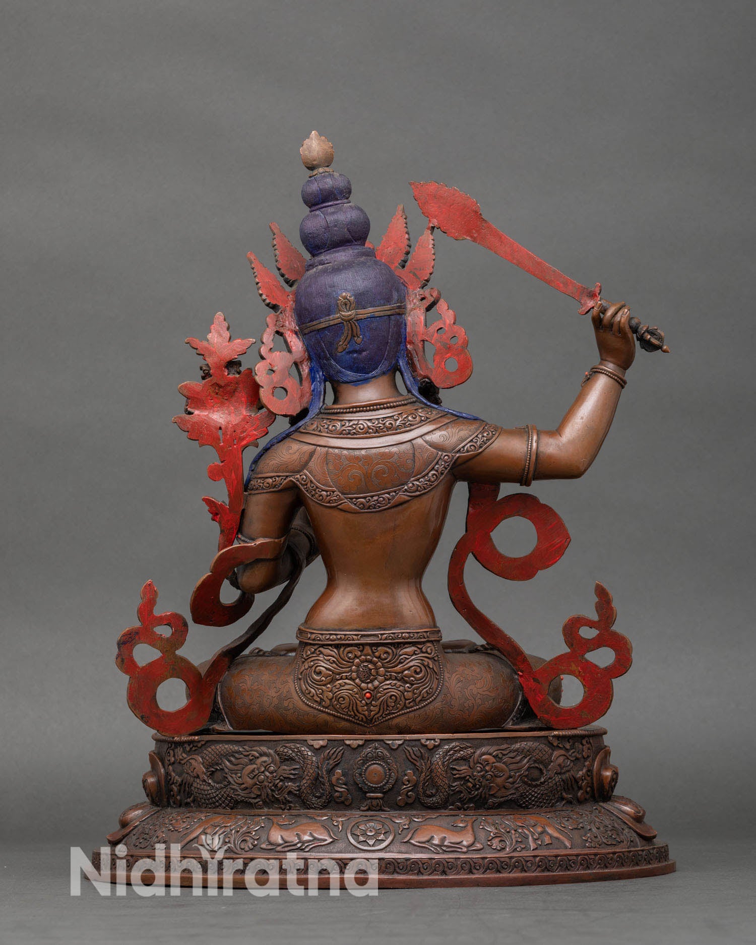 Back view of Manjushri statue highlighting intricate sacred details and semi-precious stones.