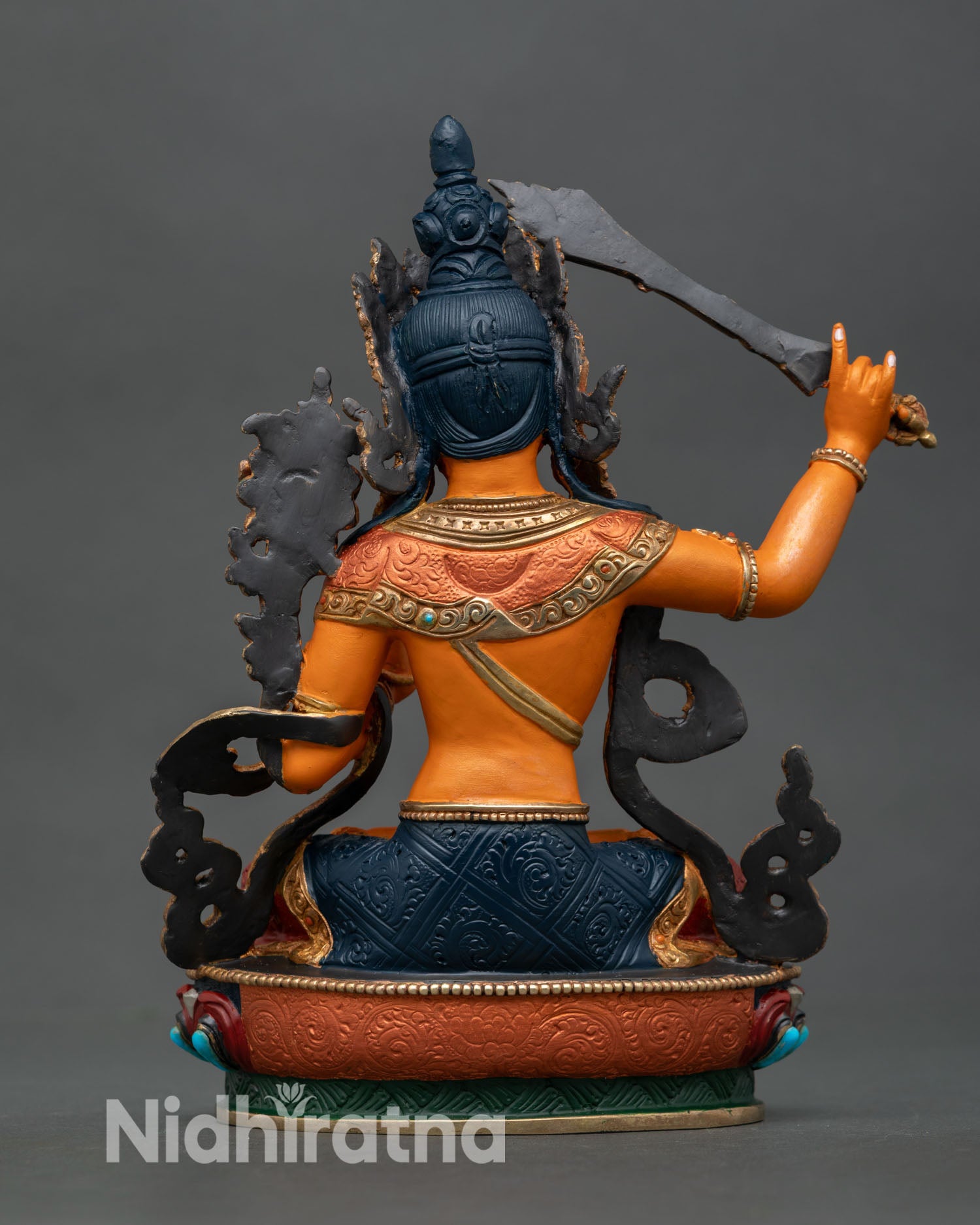 Back view of Manjushri statue multicolored robes gold ornaments Newari artisan craftsmanship copper Buddhist wisdom deity spiritual home decor