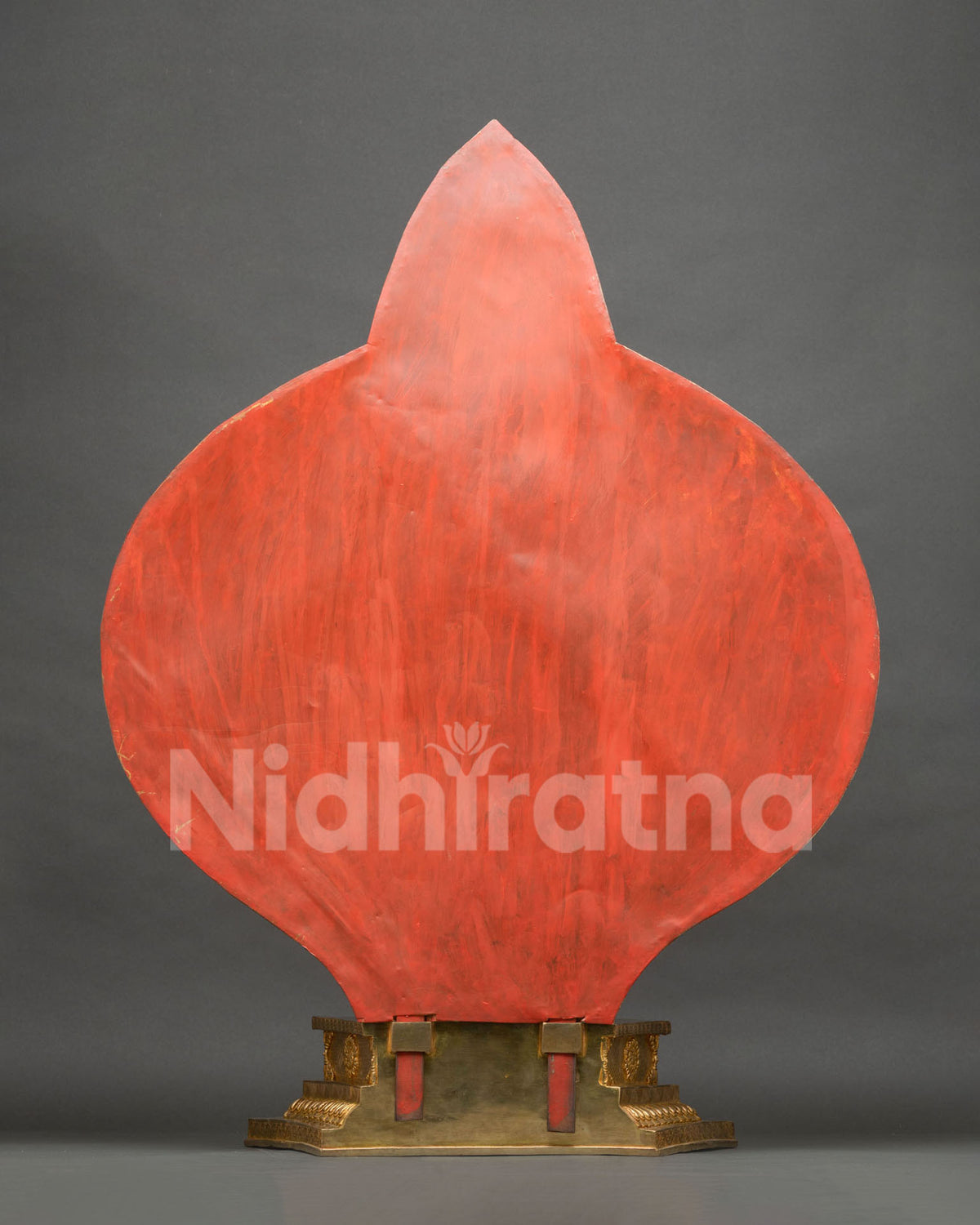 Back view of 1000-armed Chenrezig statue showing red-painted backdrop panel and copper base