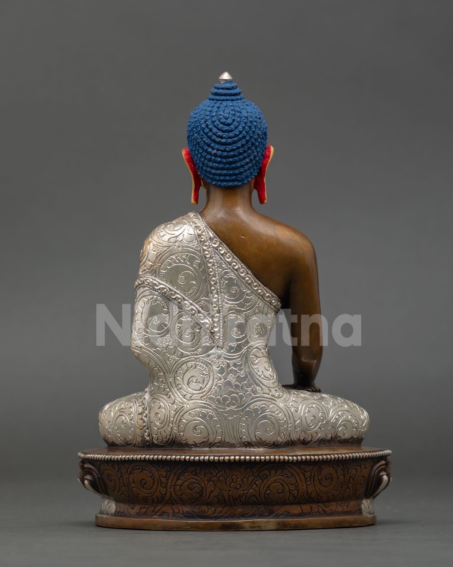 Back view of a Nepalese Shakyamuni Buddha sculpture with intricate silver-plated artisan detailing.