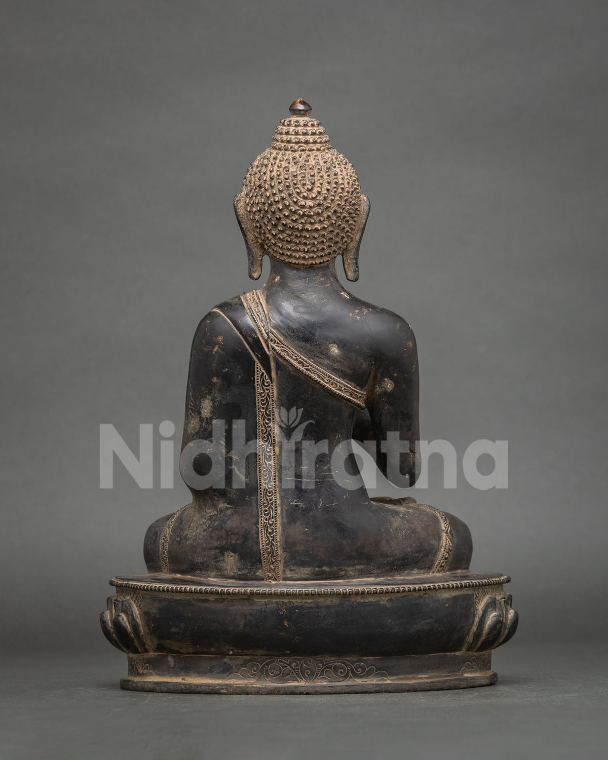 Back view of Amoghasiddhi Buddha statue showing detailed robe, lotus pedestal and copper finish