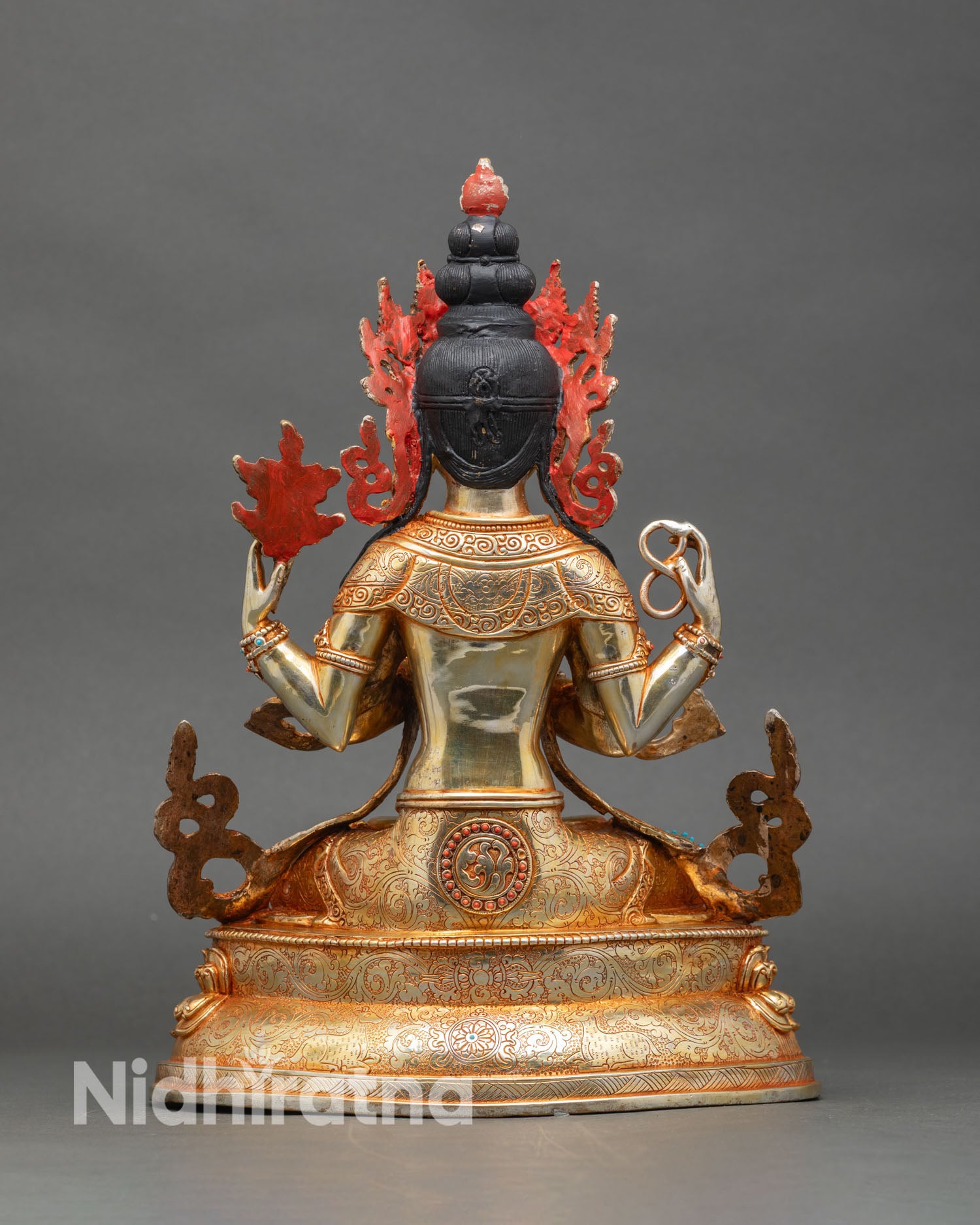 Back view of Avalokiteshvara statue showing engraved halo, robe folds, and sealed consecration base