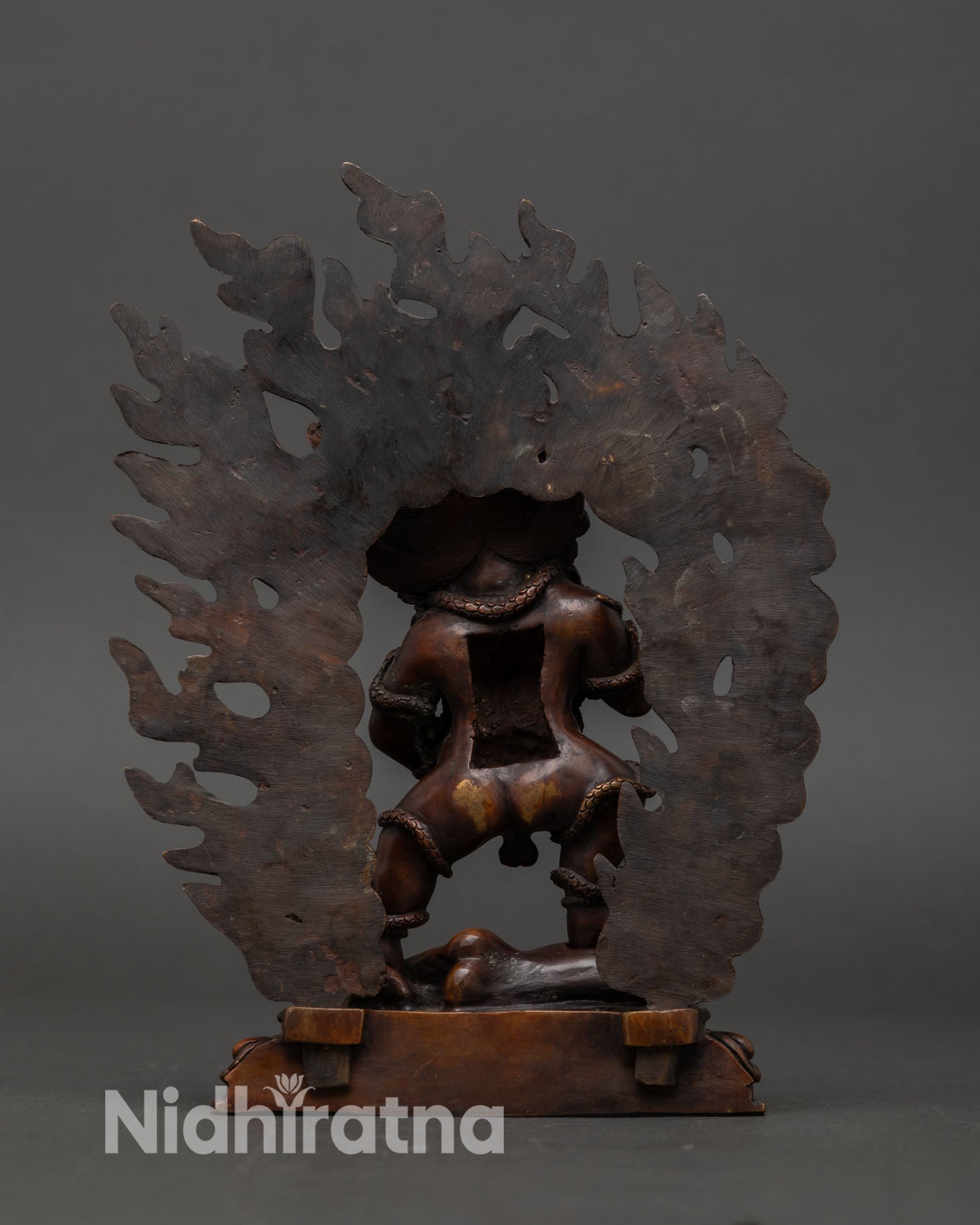 Back view of Black Dzambhala statue, showing detailed halo, representing Vajrayana wealth protector deity art.