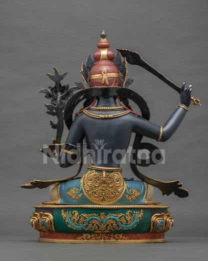 Back view of Black Manjushri statue showing hand-chased repoussé robe detail and gold gilded lotus base