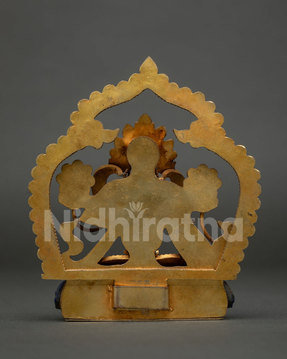 back view of copper green tara statue from nepal showing filigree halo and lotus base