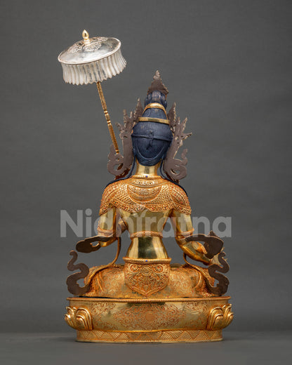 Back view of Dukar Statue with intricately engraved gold-gilded robe and silver parasol, Nepal