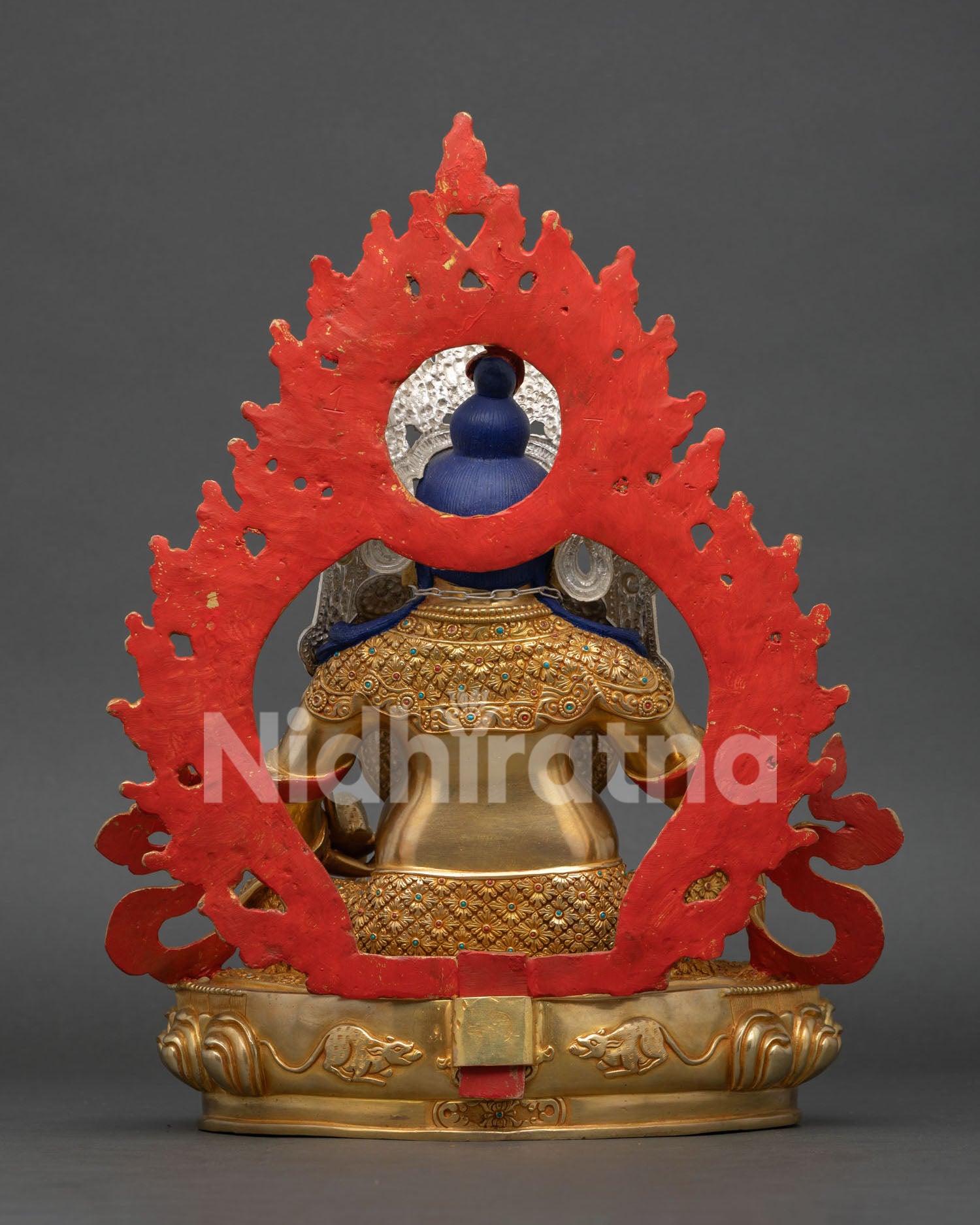 Back view of Dzambhala Statue revealing intricate halo design, lotus throne, traditional metalwork, and Newari craftsmanship