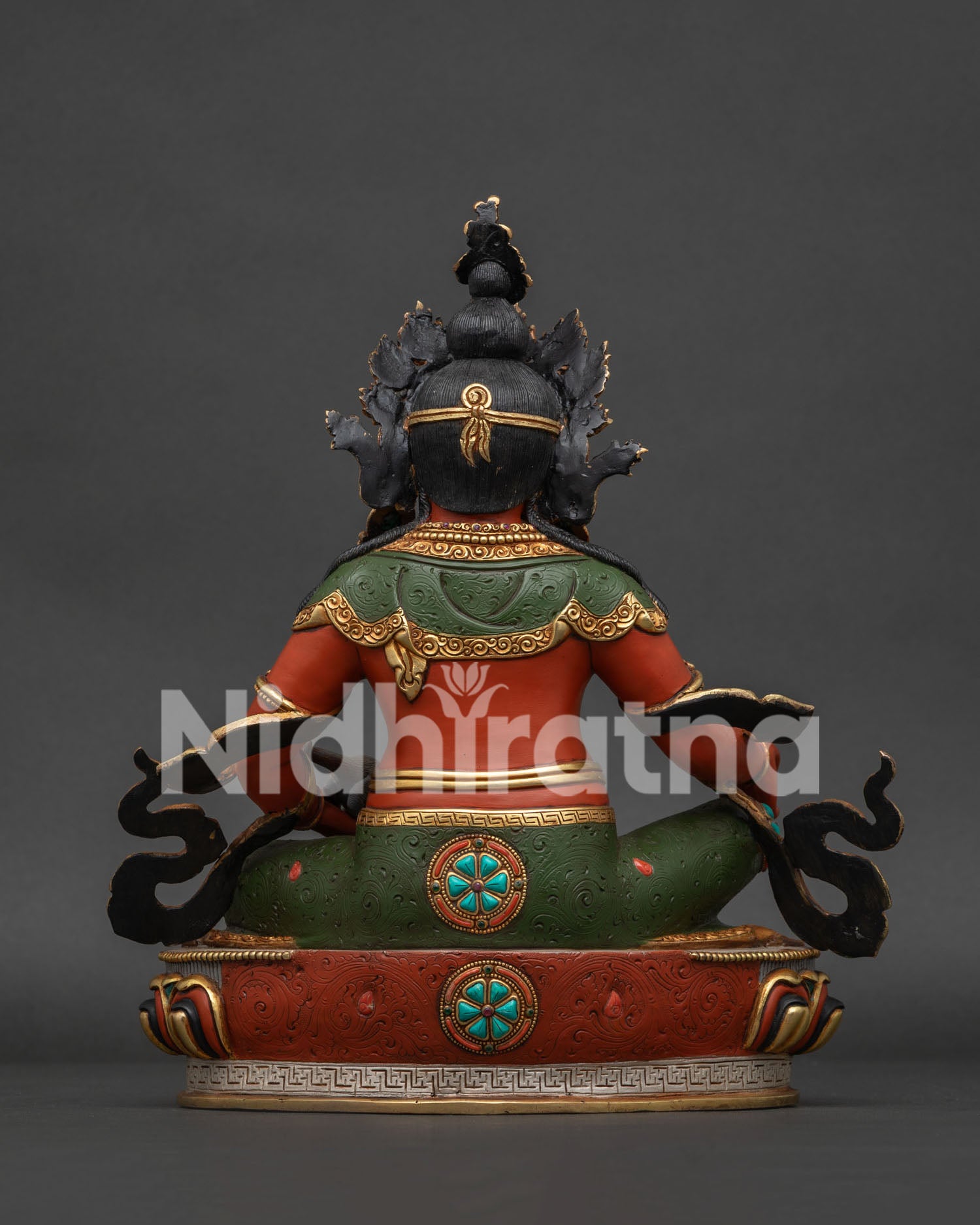 Back view of Dzambhala statue showing etched green robes, black topknot, and detailed gold lotus base.