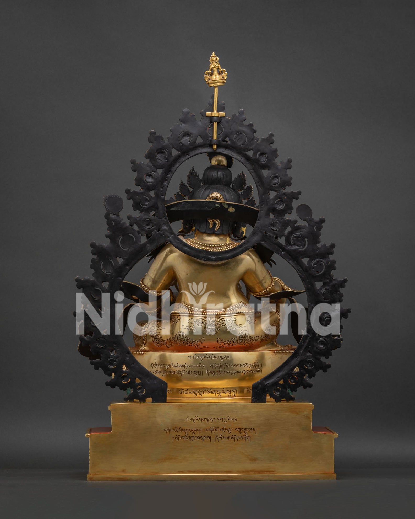 Back view of Dzambhala Statue showing gilded robes and serpent detail