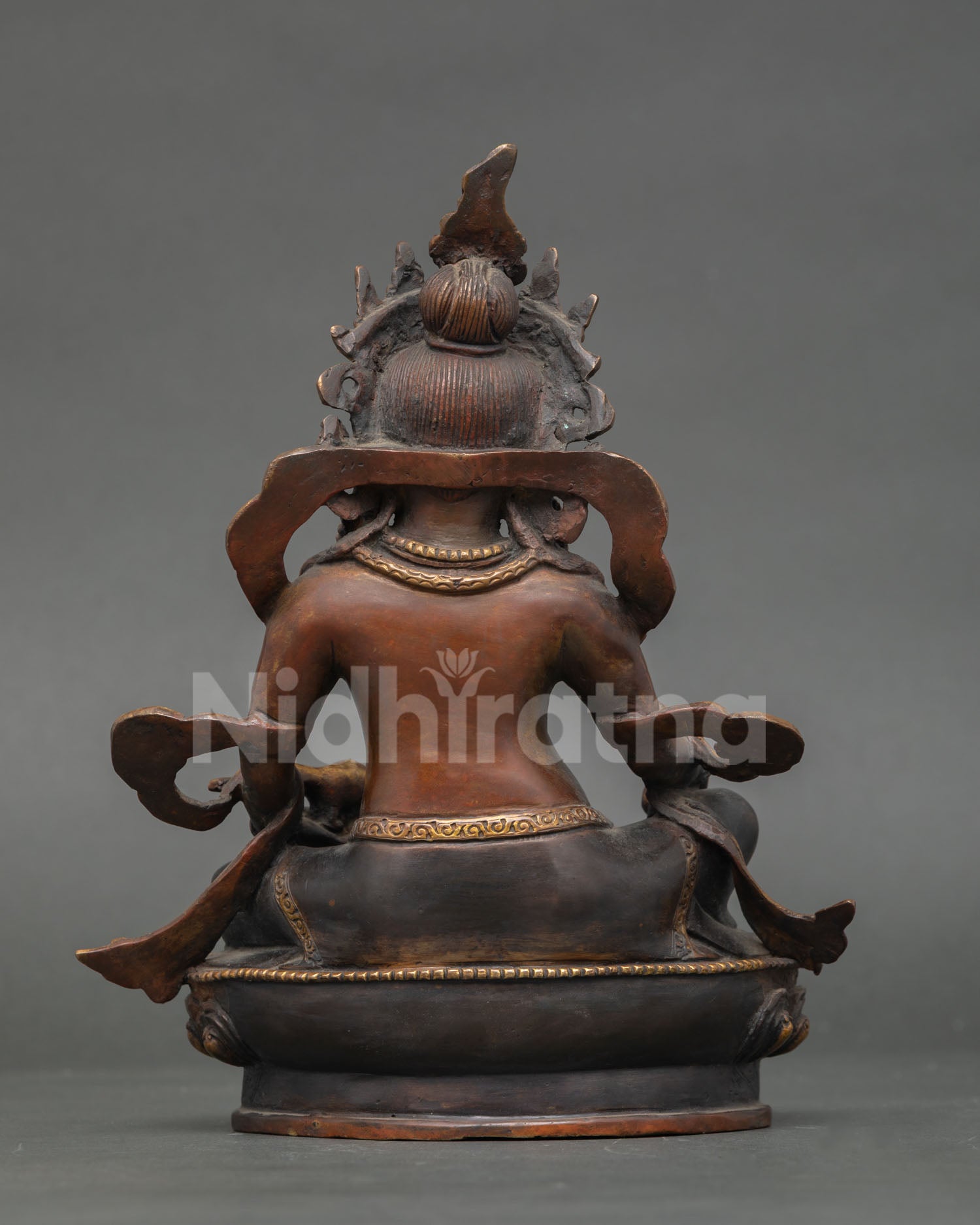 back view of dzambhala statue showing lotus pedestal and traditional nepali metalwork