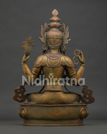 Back view of Four Armed Chenrezig statue with detailed carvings and antique oxidized copper finish.