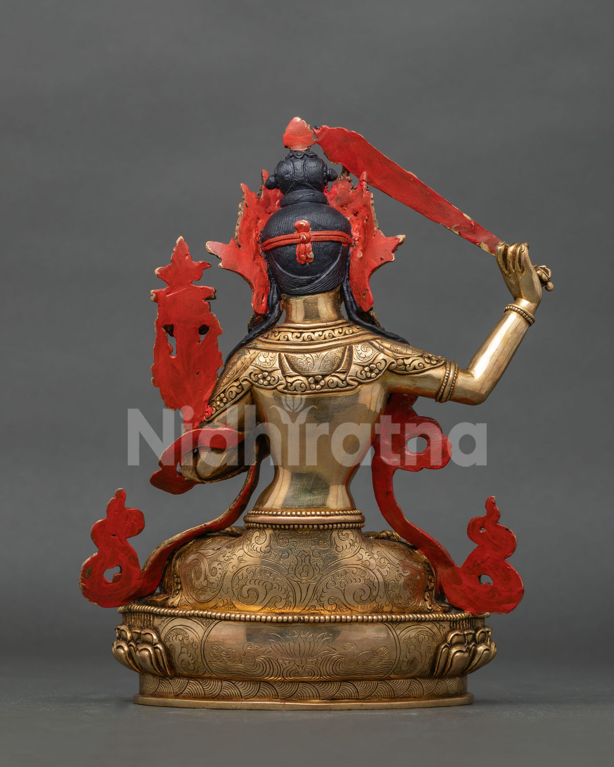 Back view of gold fire gilded manjushri statue with intricate newari craftsmanship.
