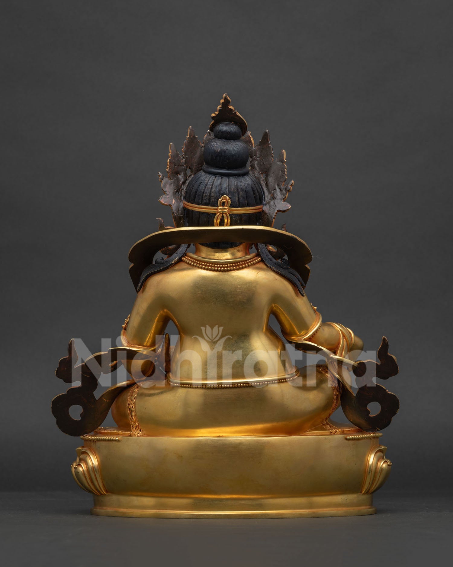 Back view of gold gilded copper Dzambhala statue showing crown and robe detail