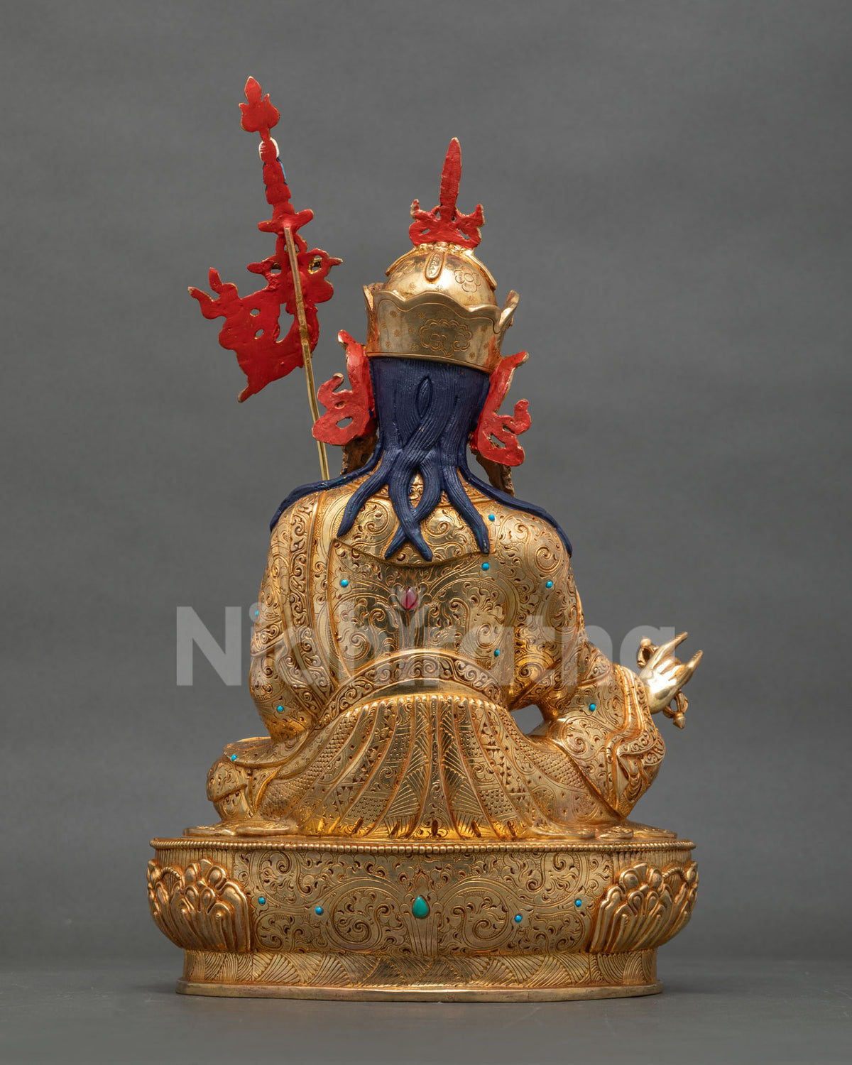 Back view of gold gilded Guru Rinpoche statue with engraved robe and sculpted hair