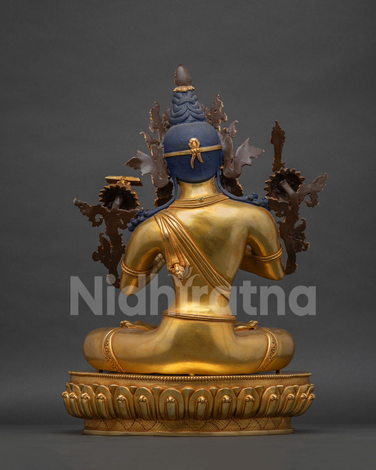 Back view of gold gilded Manjushri statue showing braided hair and crown