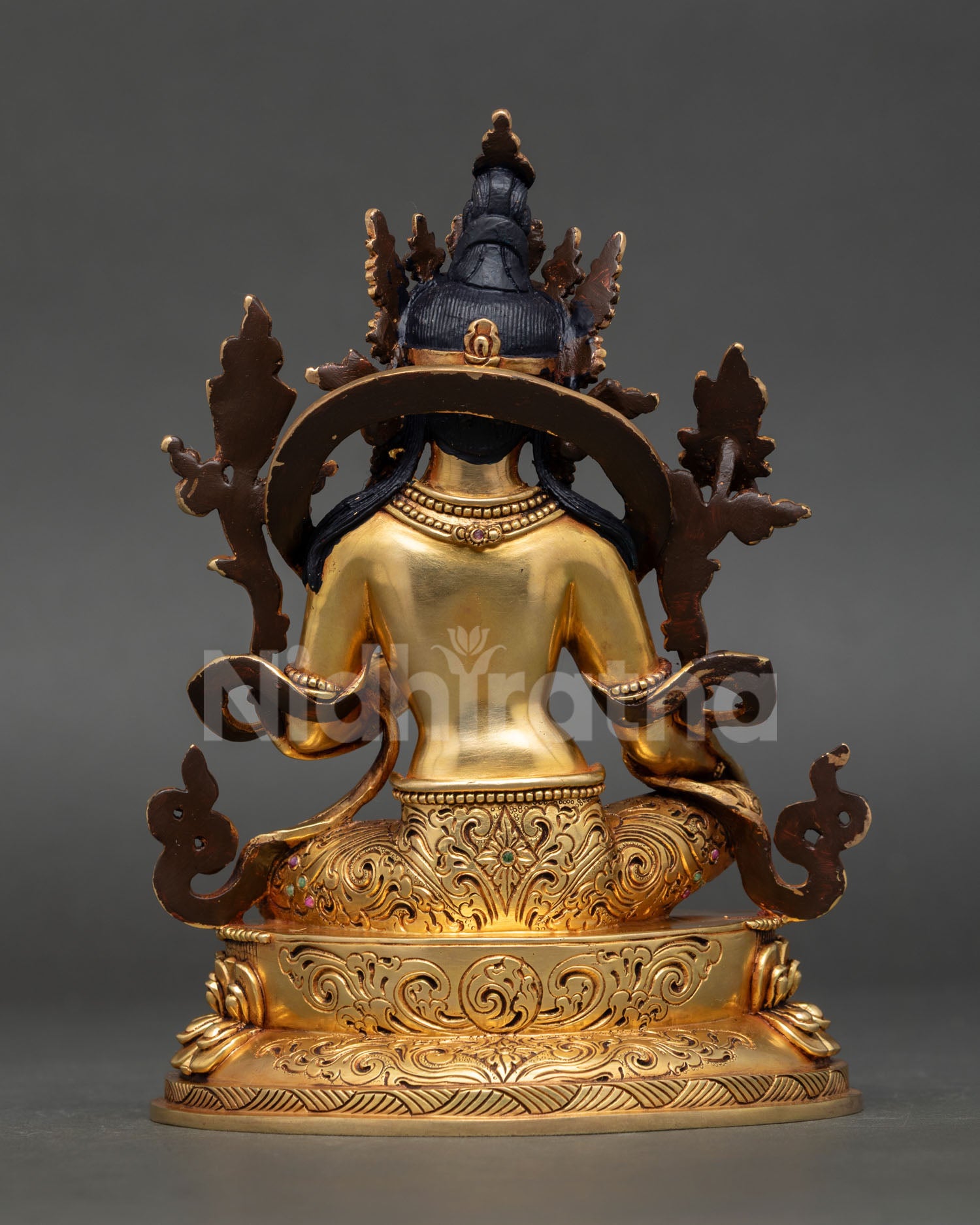 back view of green tara statue highlighting engraved robe details, lotus throne base and artisan workmanship