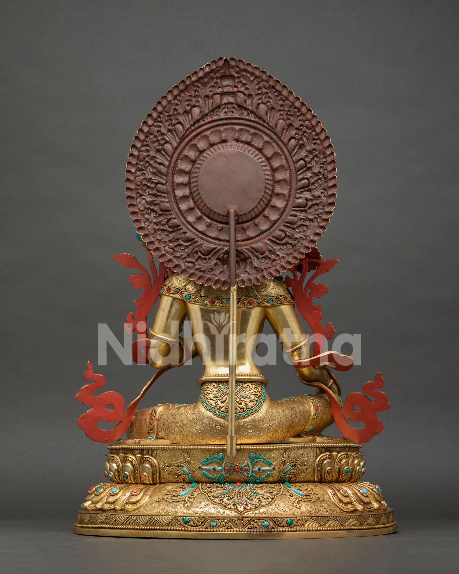 Back view of Green Tara statue revealing intricate halo carvings and handcrafted copper detailing