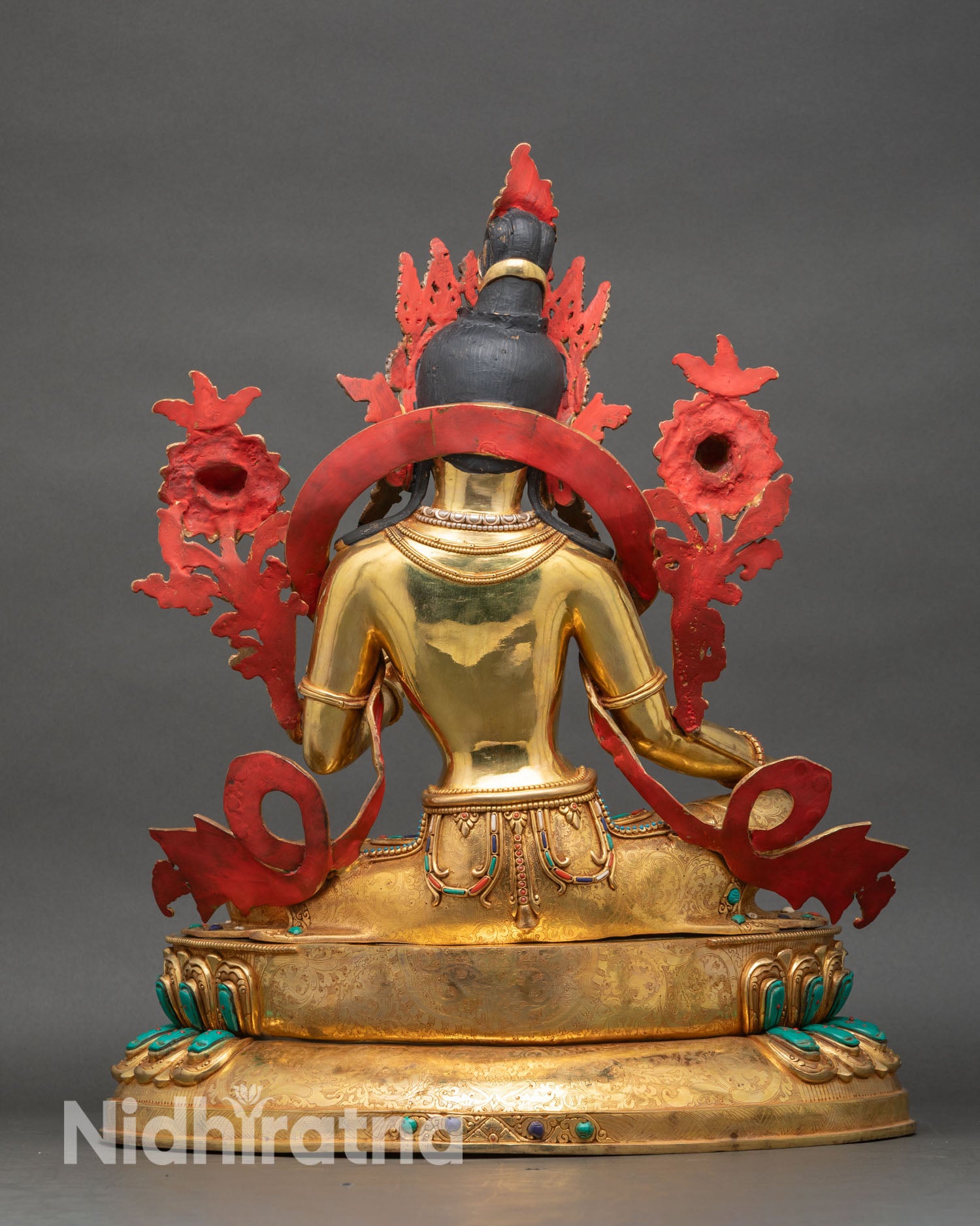 Back view of Green Tara statue revealing sculpted halo, throne details and copper work