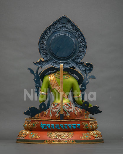 Back view of Green Tara statue with carved blue halo and mantra inscription on lotus base