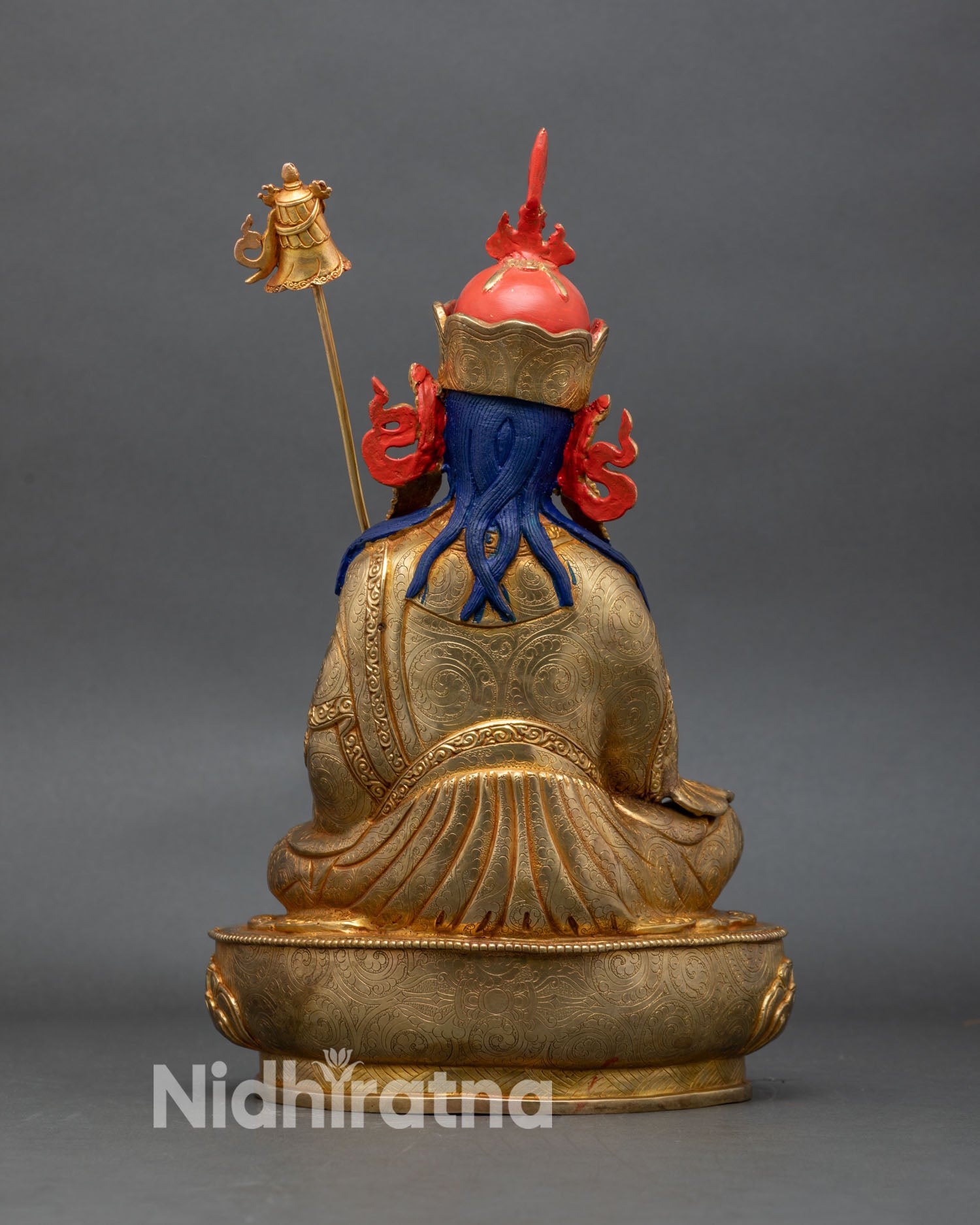 back view of guru norlha statue with lotus throne and finely engraved robe patterns