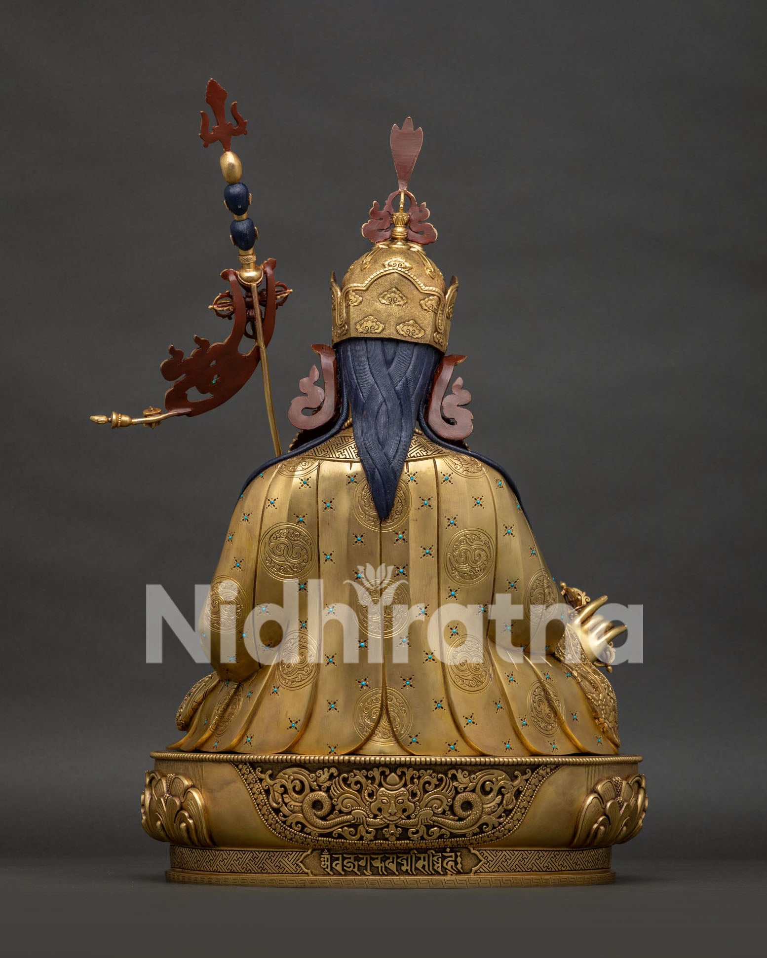 Back view of Guru Rinpoche copper statue showing kirtimukha face detail
