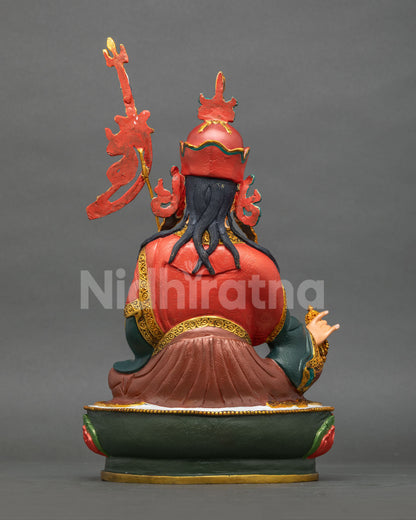 Back view of Guru Rinpoche statue with carved robe, flowing hair and banner, Padmasambhava