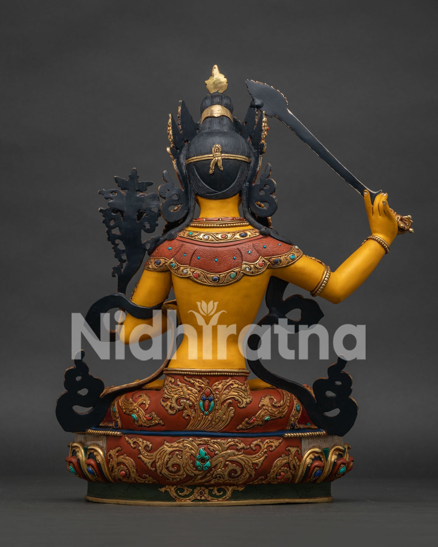 Back view of hand-painted Manjushri statue with braided hair and lotus pedestal