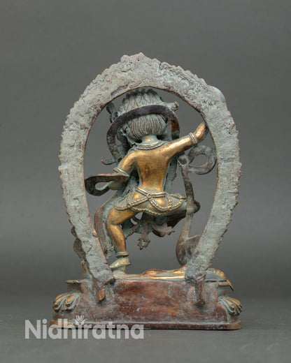 Back view of handcrafted Dorje Phagmo statue from Nepal showing antique patina detailed metal craftsmanship and flaming halo design 