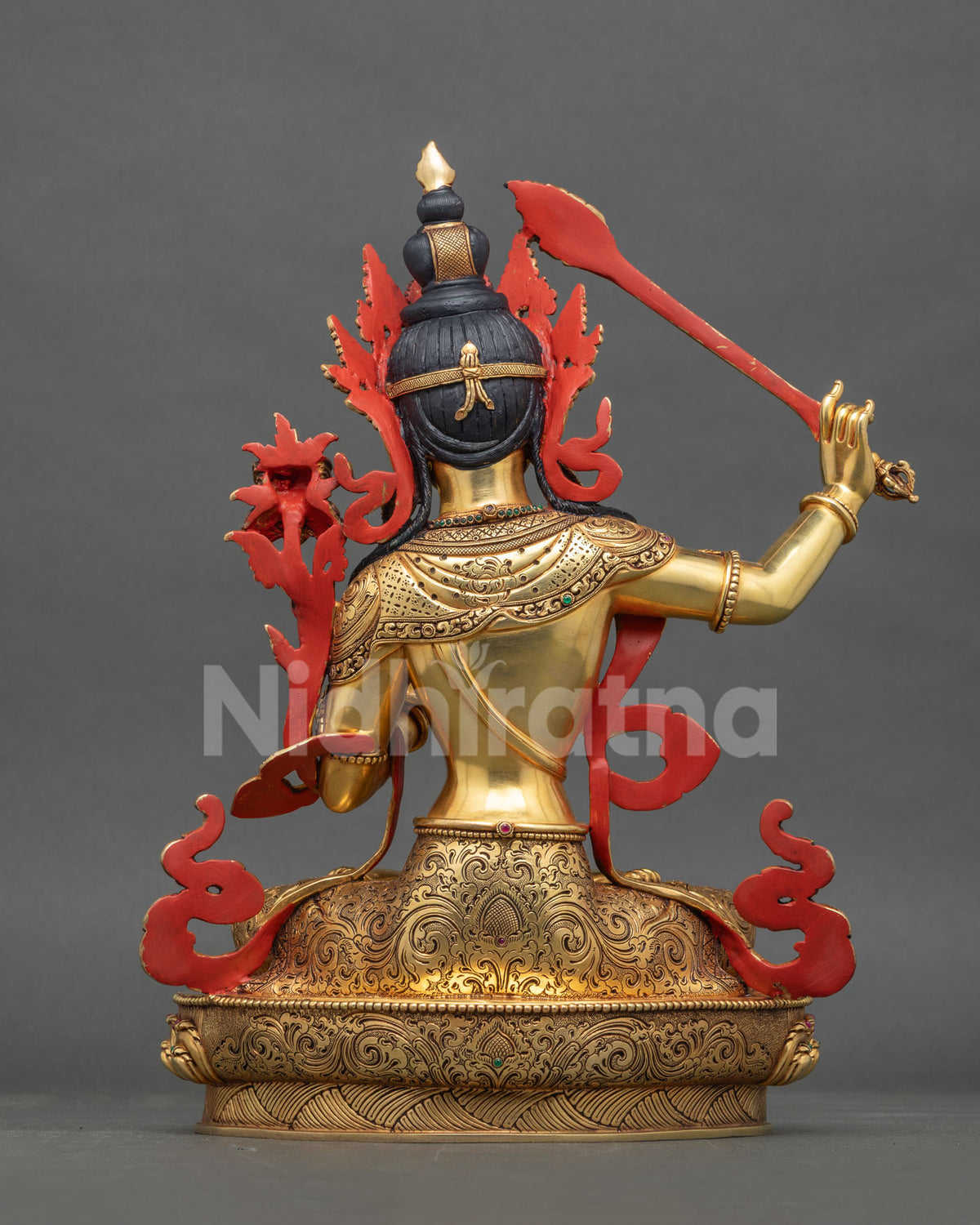 Back view of handcrafted gold-gilded copper Manjushri statue with carved details