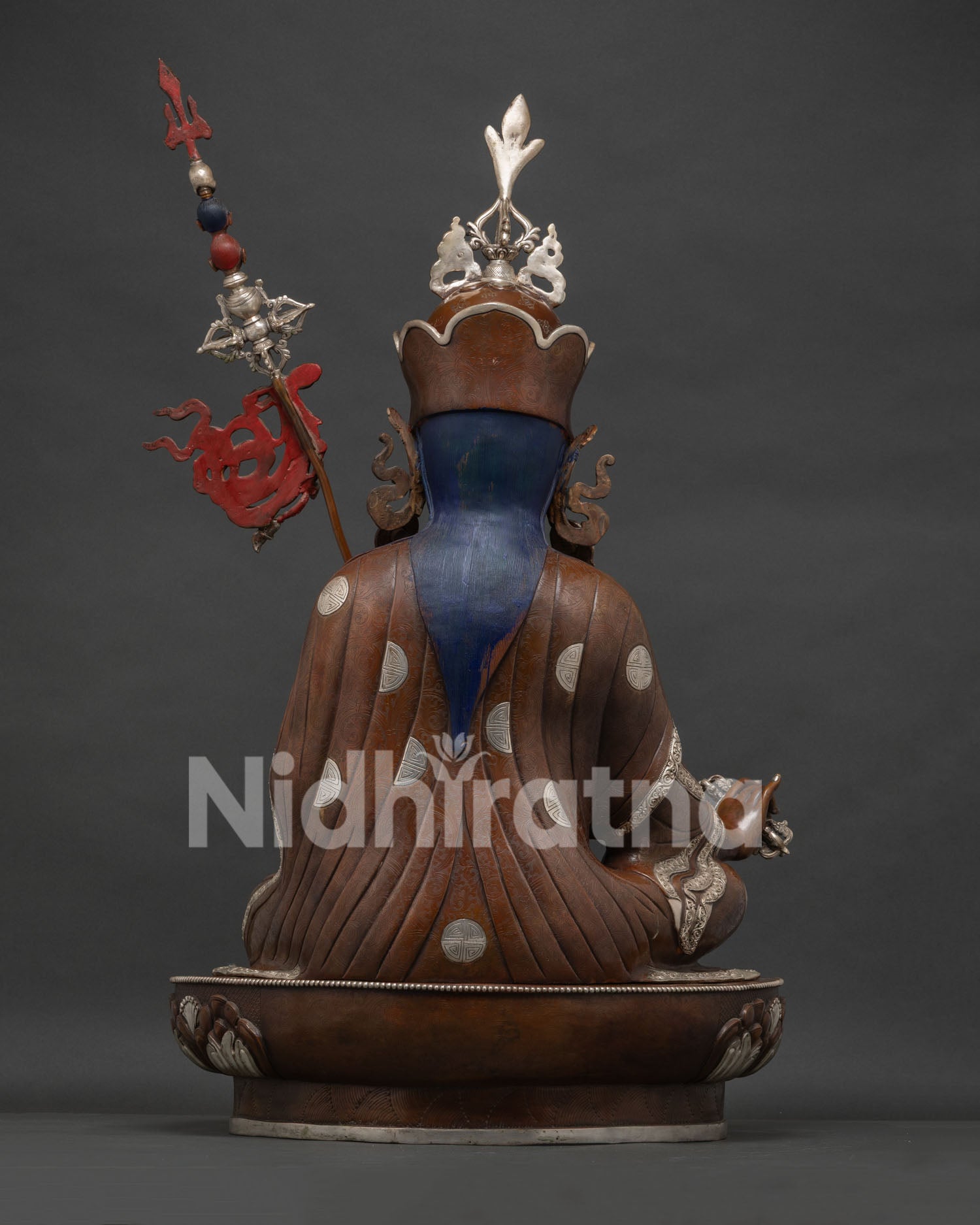 Back view of handcrafted Guru Rinpoche copper statue with intricate lotus seat detail.